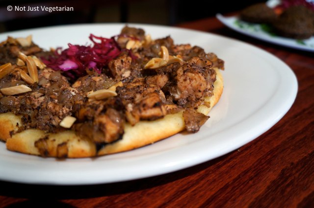 Musakhan - flat bread topped with marinated chicken, caramelized onions and toasted almond slivers at Tanoreen NYC